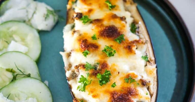 Stuffed eggplant with feta cheese and cucumbers on a plate.